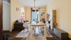 A dining area with a table, chairs, a bench, a sofa, and a view of a balcony.