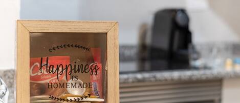 A framed sign with the text 'Happiness is Homemade' on a kitchen counter.