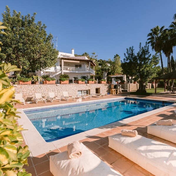 Una piscina amb gandules i una paret de pedra.