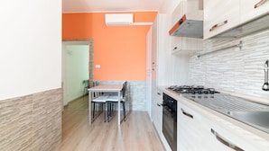 Een moderne keuken met een gasfornuis, oven en witte kastjes.
