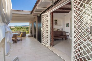 Un espacio al aire libre techado con un patio, asientos y vistas del paisaje.