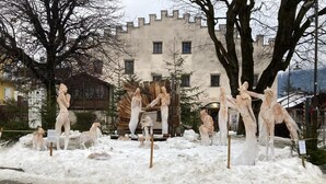 Een beeldentuin met verschillende sculpturen en een kasteelachtig gebouw op de achtergrond.