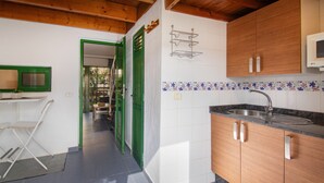 A kitchen with wooden cabinets, a stainless steel sink, and a tiled backsplash.