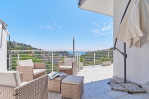 Relax on the balcony with wicker furniture, taking in the scenic coastal views.