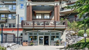 A multi-story building with a prominent balcony, a sign reading "Wolf Lodge," and a stone facade.
