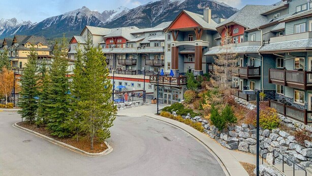 A resort with multiple-story buildings, a central courtyard, and a mountain backdrop.