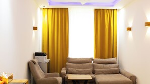 Quarto com sofá, uma mesinha e uma impressora.