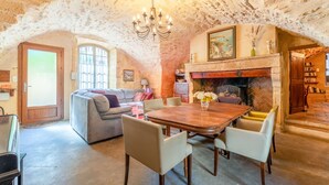 A cozy room with a fireplace, a dining table, and a sofa. - The Jasmin suite has a shared swimming pool, Wi-Fi and air conditioning (Collias)