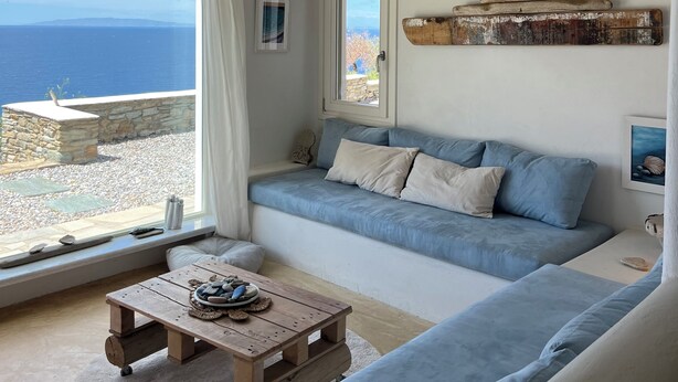 A cozy living room with a blue sofa, a wooden coffee table, and a ceiling fan.