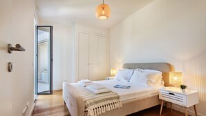 A bedroom with a bed, bedside table, and a hanging light fixture. - Casas do Forte AG in Tavira (Tavira)