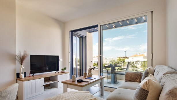 A modern living room with a flat-screen TV, a wooden coffee table, and a sofa. - Casas do Forte AG in Tavira (Tavira)