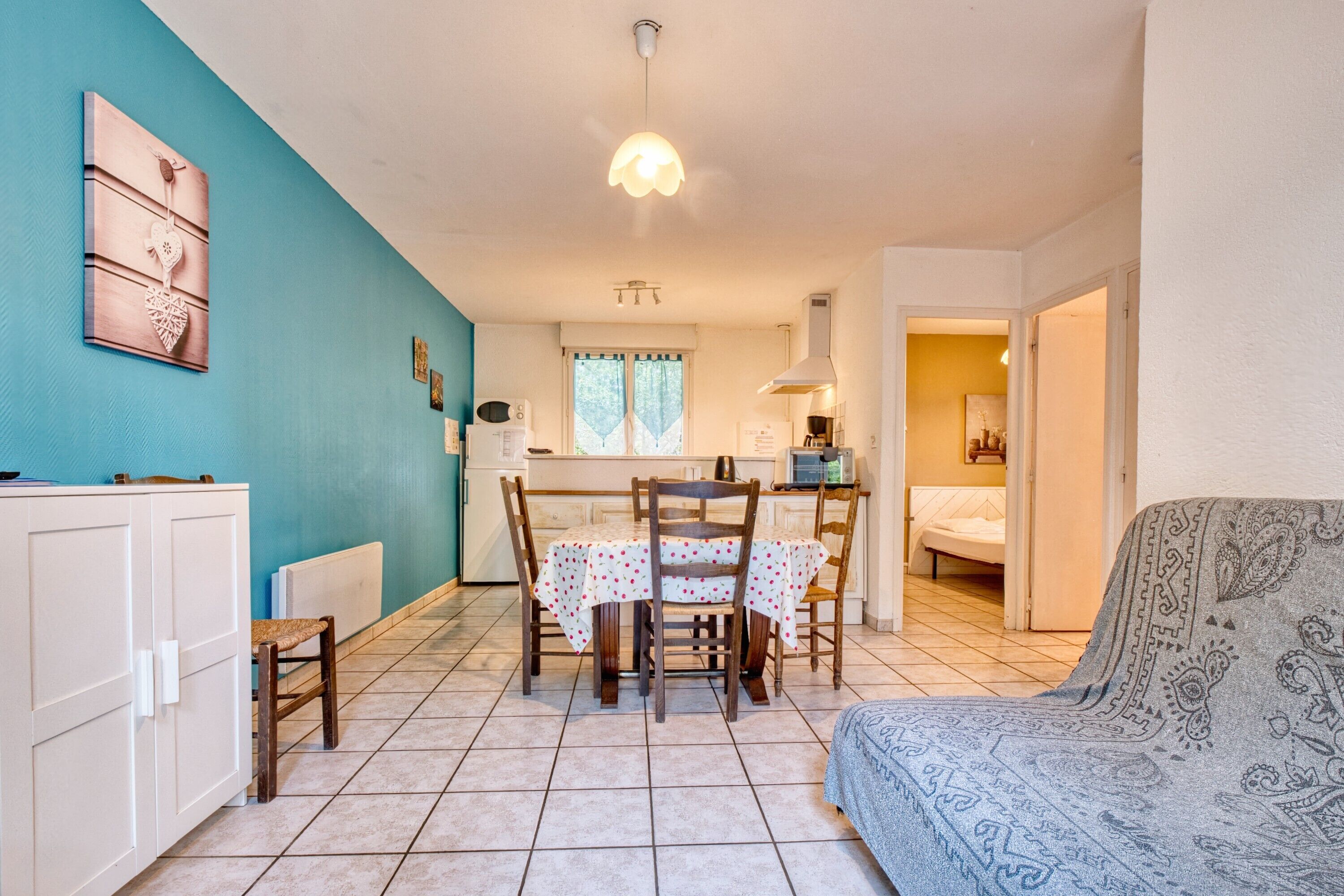 A compact living space with a dining area, kitchenette, and a sofa.