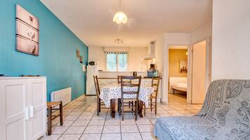 A compact living space with a dining area, kitchenette, and a sofa.