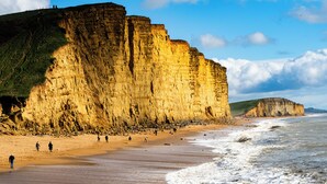 A coastal landscape with cliffs and a sandy beach. - Countryside Escape on Historic Estate (Mapperton)