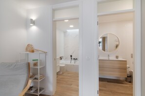 A modern bathroom with a bathtub, toilet, and vanity.