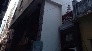 A multi-story building with a white facade, several windows, and a visible antenna. - Hotel Shiv Ganga (Varanasi)