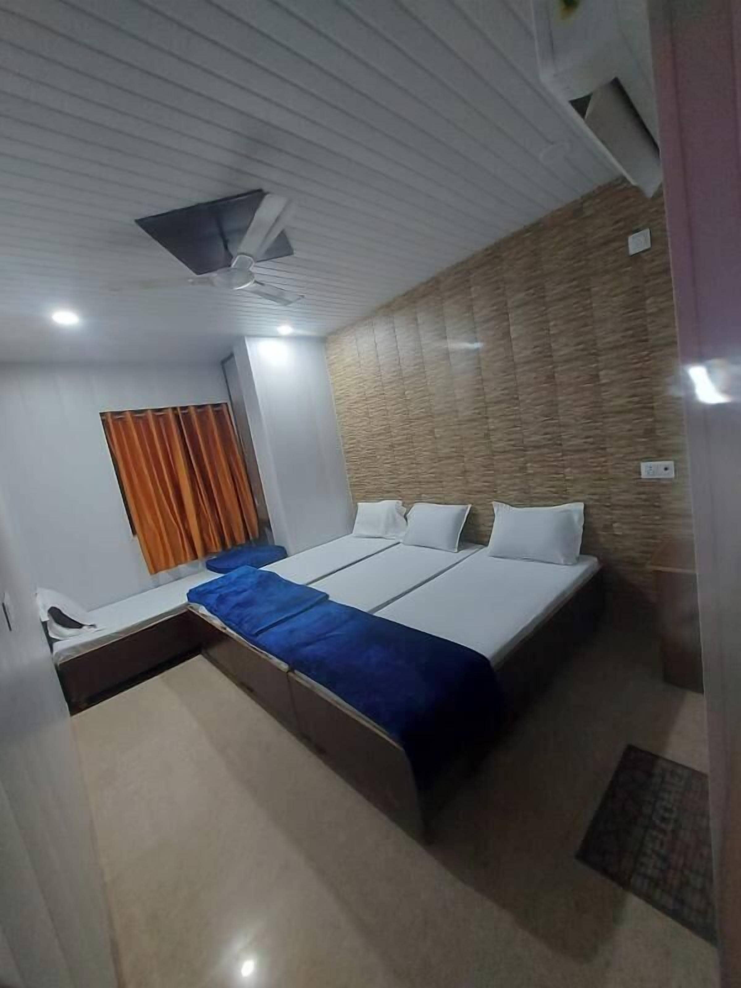 A hotel room with a bed, a desk, and a ceiling fan.