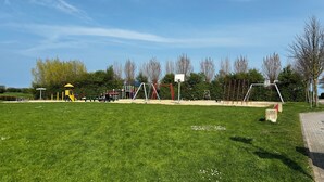 A playground with various play structures, a basketball hoop, and a picnic area. - Vacation apartment no. 2 with its own jetty/barge (Maasholm)