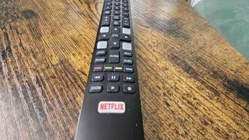 En svart fjärrkontroll med Netflix-logotypen på undersidan.