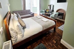 A neatly made bed with pillows, a wooden headboard, and a small rug on a wooden floor. - Sleep 6 Seaside Escape - Ev22kwh,self Check-in (Portsmouth)