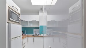 Una cocina moderna con microondas, refrigerador y pileta.