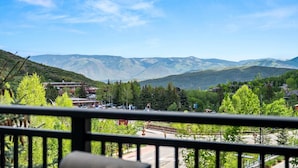Vista de la montaña con un pueblo en primer plano, que incluye edificios y un estacionamiento.