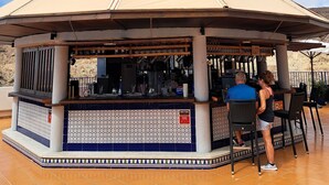 Um gazebo com chão de azulejos e espaço para bar.
