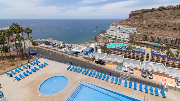 Resort com área de piscina, praia e vista para o mar.