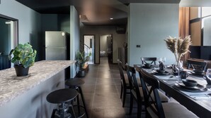 Una cocina moderna con encimera de mármol, refrigerador empotrado y plantas en macetas.