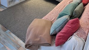 Un salon moderne avec un canapé, un téléviseur et une étagère décorative.