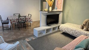 Un salon avec une cheminée, une table à manger avec des chaises et un canapé.