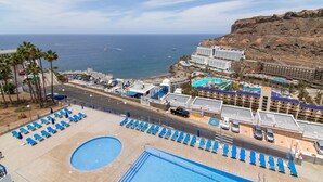 A resort with a pool area, beach, and ocean view. - Stunning Sunset Ocean View Vacation – Ocean Views, Shared Pool & Wi-Fi (Taurito)