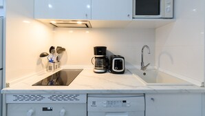 A compact kitchen with a built-in dishwasher, a microwave, and a coffee maker. - Monthly Rental in Madrid - Modern 1 bedroom flat (Madrid)