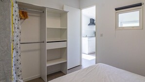 Een slaapkamer met een bed, een kledingkast en een raam.