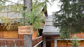 A lodge with a wooden exterior, a sign reading "Accès Privé Chasse Forêt," and a stone entrance. - Renovated apartment in Méribel, near slopes, fiber included (Méribel)