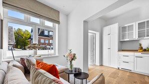 Un apartamento moderno con sala de estar, cocina y ventanas amplias.