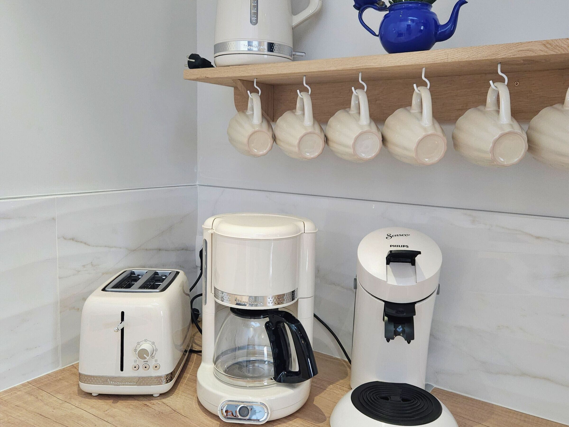 A kitchen with a toaster, a coffee maker, and a water dispenser on the counter.