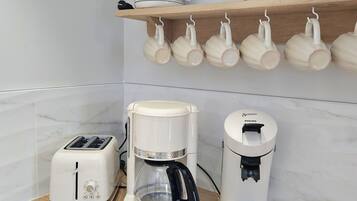A kitchen with a toaster, a coffee maker, and a water dispenser on the counter.