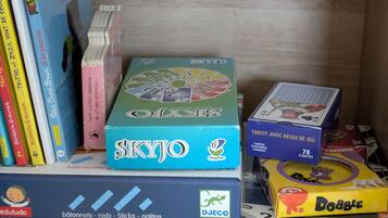 Uma seleção de jogos de tabuleiro e livros em uma estante.