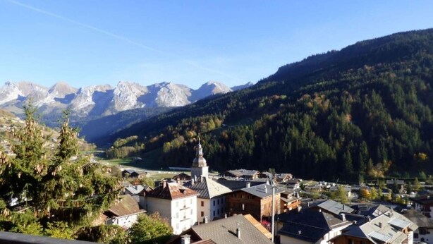 A town with a prominent church, surrounded by mountains and dense forests. - Charming 4-room + mezzanine for 8 people in Grand-Bornand (Le Grand-Bornand)
