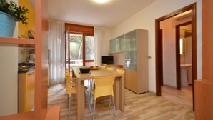 Una cocina moderna con zona de comedor, suelo de madera y un ventanal grande.