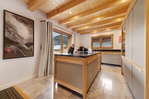 Una cocina con vigas de madera, un ventanal y un cuadro en la pared.