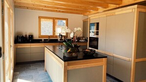 Una cocina moderna con armarios de madera, encimera negra y una isla central con un jarrón de flores.
