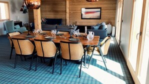 Un comedor con suelo a cuadros, mesas de madera y sillas de mimbre.