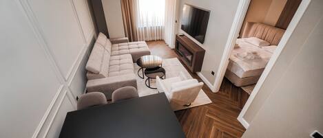 Un espacio habitable funcional con un conjunto de sofás, una mesa de comedor y un televisor.