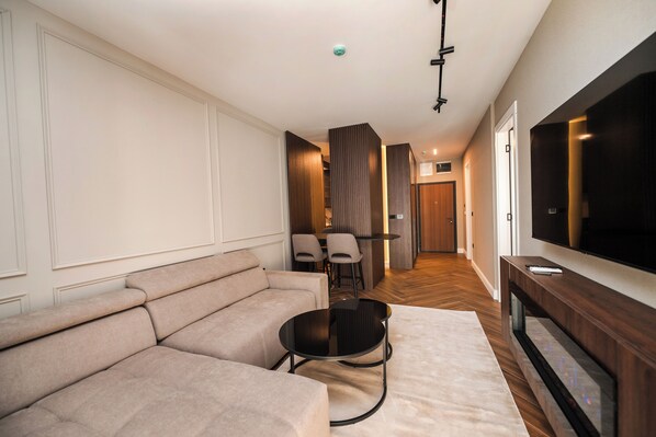 Deluxe-Apartment, Balkon, Stadtblick | Wohnbereich | 64-Zoll-LED-Fernseher mit Satellitenempfang