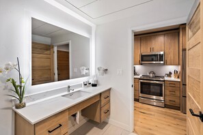 A modern kitchen with stainless steel appliances, wooden cabinets, and a white countertop.
