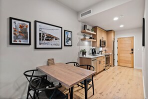A modern kitchen with wooden cabinets, a built-in oven, and a microwave.