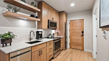 Une cuisine moderne avec des meubles en bois, des appareils en acier inoxydable et un plan de travail en marbre.