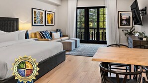 Un dormitorio moderno con cama, sofá y un comedor con mesa y sillas.